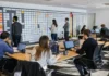 One Cyberattack Now Triggers Hundreds of Breach Reporting Obligations A spacious office with a long table of laptops, people working