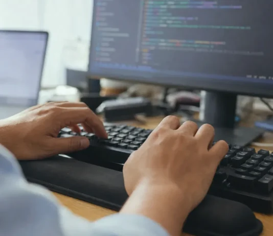 Anthropic’s AI Security Tests Broke Into Three Real Companies Close-up of hands mid-keystroke on a keyboard, with a blurred monitor