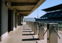 Ajax Cyber Breach Exposed 300,000 Fan Records and Stadium-Ban Controls Empty stadium concourse in bright daylight, featuring turnstile barriers and a view of the stands, shot from ground level.
