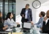 The Biggest CISO Challenges of 2026: 73% Still Aren’t Ready for a Major Attack A CISO in business attire stands at a glass conference table, discussing with colleagues around a laptop and clock on the wall.