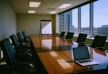 CISO Board Reporting: Gartner Says Drop the Dashboard, Use Financial Statements Brightly lit corporate boardroom with a polished conference table, empty chairs, and a presentation board at the front.