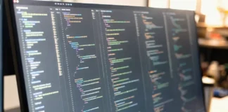 Close-up of a brightly lit computer screen displaying a code editor with multiple panes of disassembly output and hex values.
