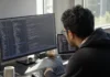 Supply Chain Security Breach at ShapedPlugin Backdoored Paying Customers A developer sits at a desk, focused on dual monitors displaying a blurred code editor