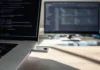 Close-up of a hardware security key being inserted into a laptop's USB-C slot on a brightly lit desk.