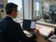 A Quarter of CISOs Considered Quitting as AI Governance Landed on Them A CISO-level executive in business attire sits at a desk, reviewing a laptop