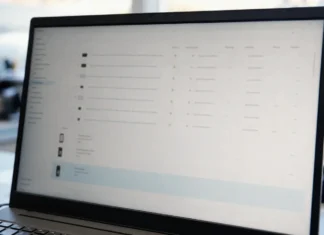 Helpdesk Impersonation: The Four Post-MFA Stages CISOs Need to Detect A laptop monitor displays a brightly lit authentication management console with a list of identity provider devices.