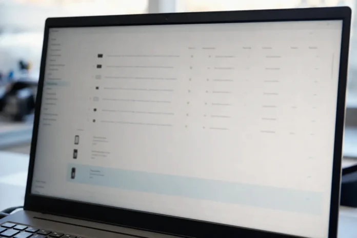 A laptop monitor displays a brightly lit authentication management console with a list of identity provider devices.